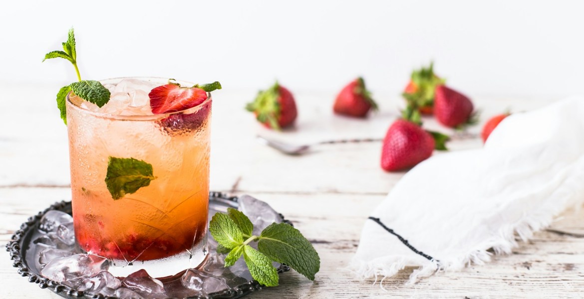 glass of mint and strawberry beverage on brown panel