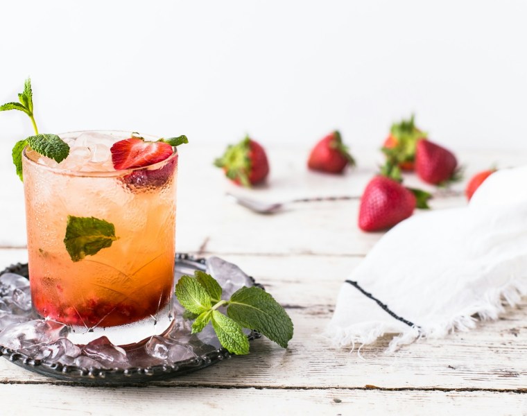 glass of mint and strawberry beverage on brown panel