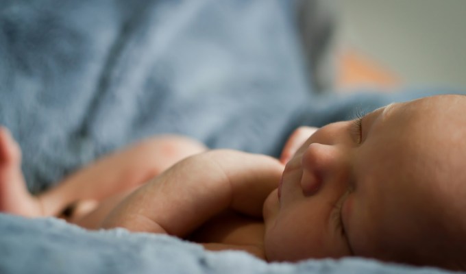 closeup photo of baby on blue blanket