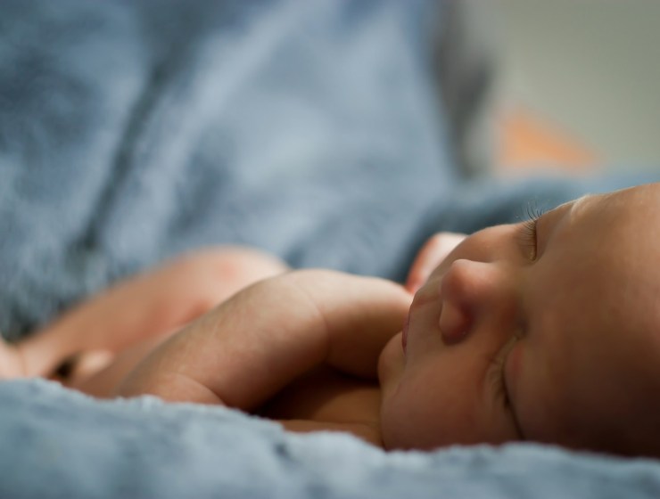 closeup photo of baby on blue blanket
