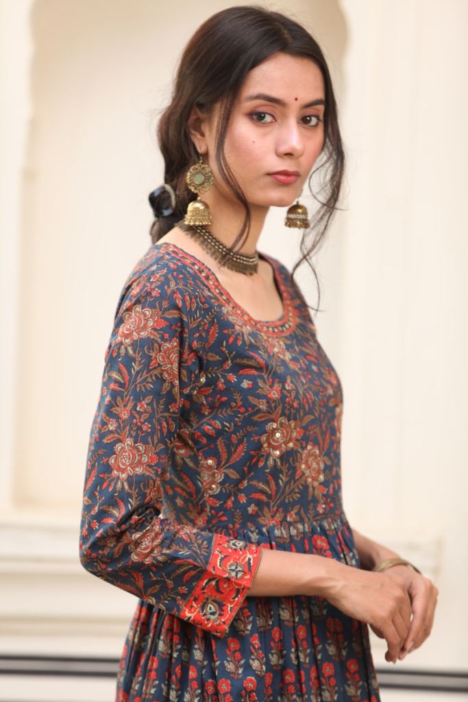 a woman in a dress with a necklace and earrings