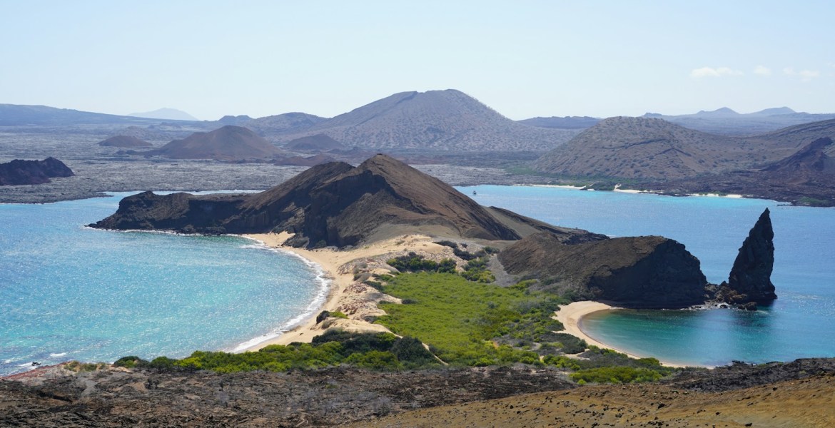 an island with a sandy beach and blue water