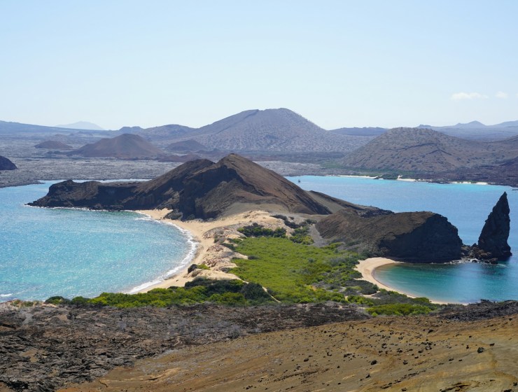 an island with a sandy beach and blue water