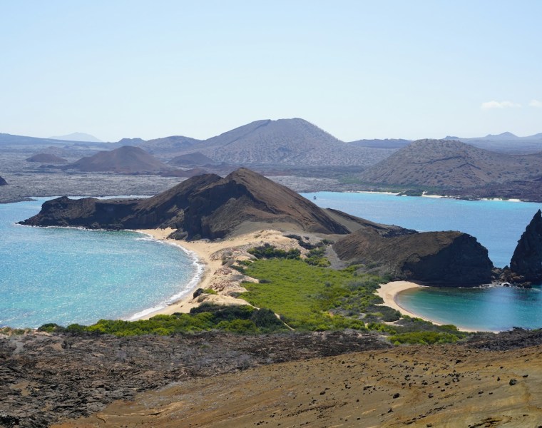 an island with a sandy beach and blue water