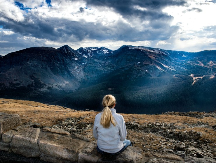 woman sitting on gray stone