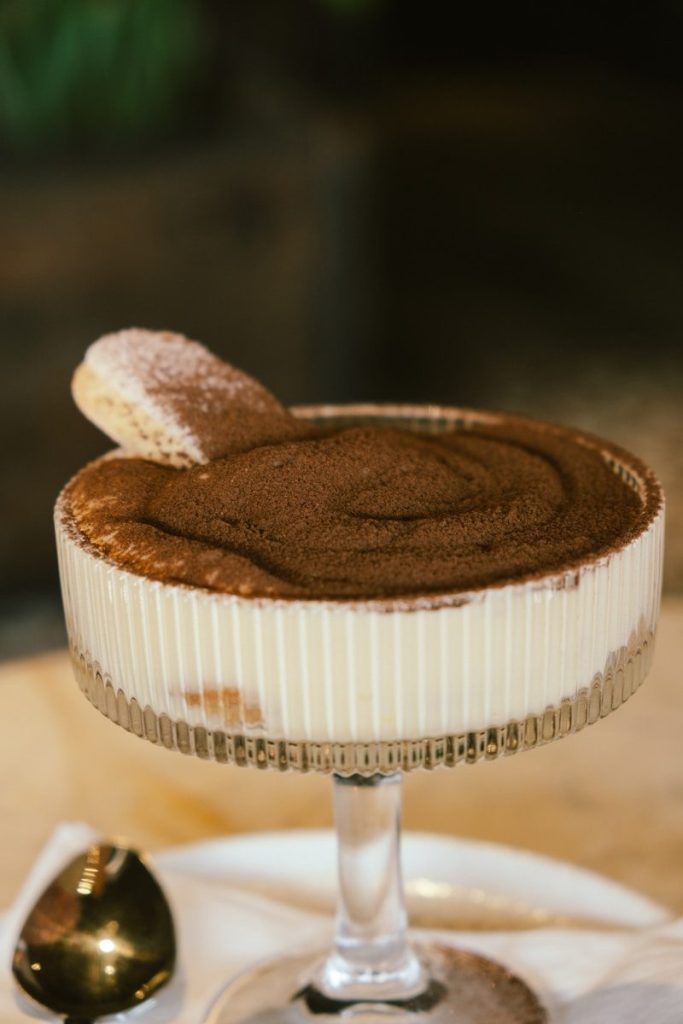A delicious tiramisu dessert in a glass dish.