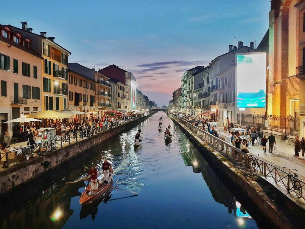 persone che vanno in barca sul fiume tra gli edifici durante il giorno