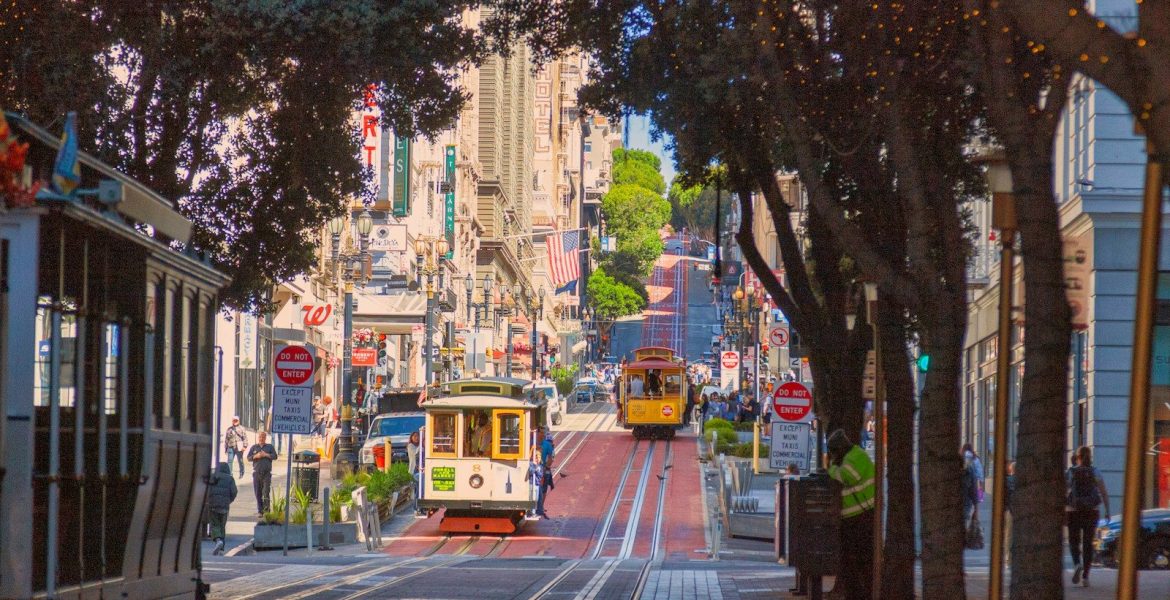 a trolley car traveling down a street next to tall buildings
