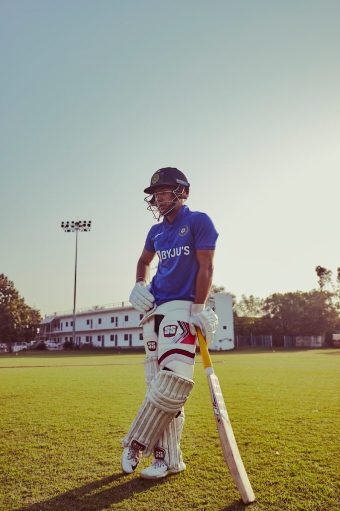 a man standing on a Cricket pitch holding a bat