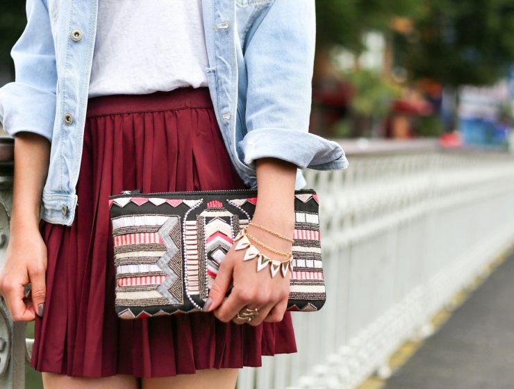 woman holding clutch bag standing beside white bridge