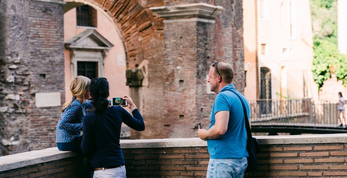 man in blue t-shirt and blue denim jeans holding black dslr camera