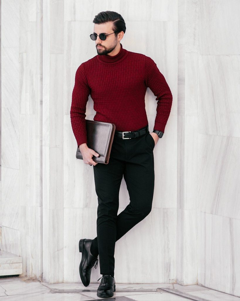 a man in a red sweater and black pants